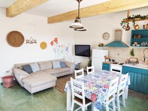 cocina y sala de estar con mesa y sofá en Casa Incantevole Vicino al Mare, en Baratili San Pietro