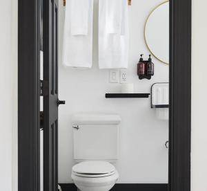 a bathroom with a white toilet and a mirror at Eastwind in Windham