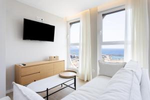 sala de estar blanca con sofá blanco y TV en Home2Book Stylish Sea Views Studio Santa Cruz en Santa Cruz de Tenerife