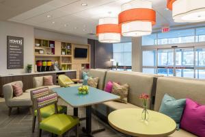 a waiting room at a restaurant with tables and chairs at Home2 Suites By Hilton Memphis East / Germantown, Tn in Memphis