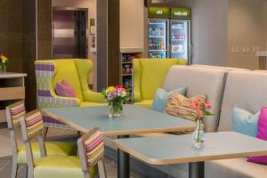 a store with two tables and chairs with flowers on them at Home2 Suites By Hilton Memphis East / Germantown, Tn in Memphis