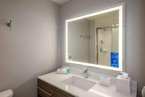 a bathroom with a sink and a large mirror at Home2 Suites By Hilton Memphis East / Germantown, Tn in Memphis
