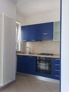 a kitchen with blue cabinets and a sink at Atlantic Roseto sul mare in Roseto degli Abruzzi
