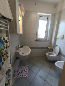 ein Bad mit einem Waschbecken, einem WC und einem Fenster in der Unterkunft Atlantic Roseto sul mare in Roseto degli Abruzzi