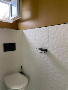 a bathroom with a white toilet and a window at Très bel appartement avec jardin reposant in Angers