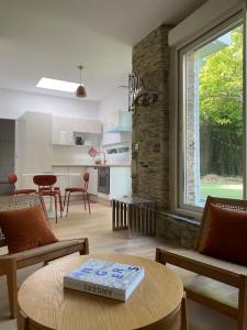 a living room with a table with a book on it at Très bel appartement avec jardin reposant in Angers