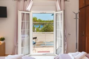 1 dormitorio con puerta que da a un balcón en Anna House, en Panteli