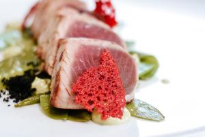 a piece of meat sitting on a white plate at Bella Hotel & Restaurant with private dock for mooring boats in San Felice del Benaco