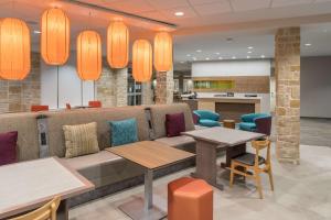 a lobby with a couch and tables and chairs at Home2 Suites by Hilton Fort Worth Cultural District in Fort Worth