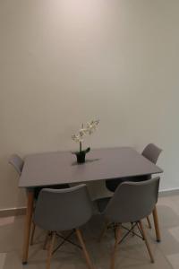 a table with two chairs and a vase with flowers on it at تاج الحمراء للاجنحة الفندقية Taj Al Hamra Hotel Suites in Riyadh