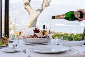 a person pouring wine into a bowl of food on a table at Bella Hotel & Restaurant with private dock for mooring boats in San Felice del Benaco