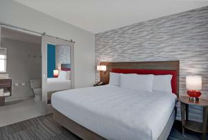 a bedroom with a large bed and a bathroom at Home2 Suites By Hilton Melbourne Viera in Melbourne