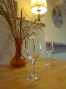 deux verres à vin et un vase sur une table dans l'établissement Curonian Coast studio, à Nido