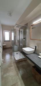 Casa Glicine في ميلاتسو: حمام كبير مع حوض استحمام ودش