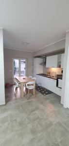 Casa Glicine في ميلاتسو: مطبخ مع طاولة وكراسي في غرفة