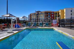 a swimming pool with chairs and tables and buildings at Tru By Hilton Rockwall Dallas, Tx in Rockwall