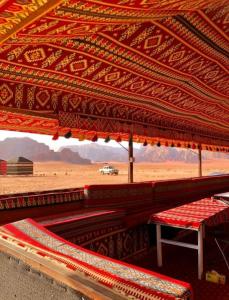 a red pavilion with a table and benches in the desert at joy of life in Wadi Rum