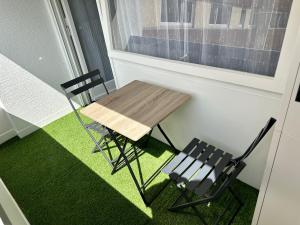 une table et une chaise assises à côté d'une fenêtre dans l'établissement Happy Studio terrace, à Schiltigheim