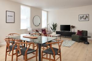 a living room with a glass table and chairs at Fulham - Hestercombe House by Viridian Apartments in London