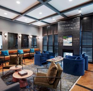a lobby with blue chairs and a fireplace at The Haywood, Tapestry Collection by Hilton in El Dorado
