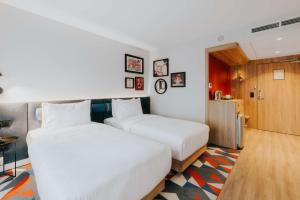 two beds in a hotel room with white sheets at Hampton By Hilton Warsaw Reduta in Warsaw