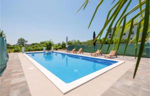 a swimming pool with chairs and a building at Lovely Home In Donji Prolozac With Wifi in Donji Proložac