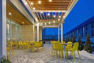 een patio met gele stoelen en tafels en een gebouw bij Home2 Suites By Hilton Richmond in Richmond