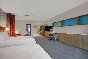 a hotel room with two beds and a desk at Home2 Suites By Hilton Richmond in Richmond