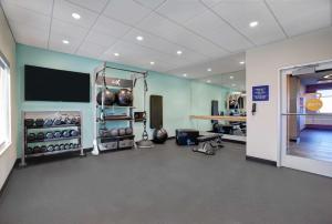 a room with a gym with a television and weights at Tru By Hilton Stoughton in Stoughton