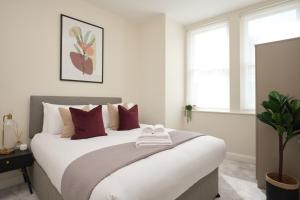 a bedroom with a large bed with red pillows at Fulham - Hestercombe House by Viridian Apartments in London