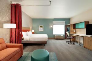 Home2 Suites By Hilton Ogden في أوغدن: غرفة في الفندق مع سرير ومكتب