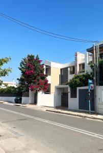 una strada vuota con un edificio e un albero con fiori rosa di Luxury maisonette near the beach a Vari