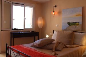 Schlafzimmer mit einem Bett, einem Fenster und einem Tisch in der Unterkunft Artistic Sea View House in Korfu-Stadt
