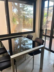 tavolo e sedie in una stanza con finestra di Luxury maisonette near the beach a Vari