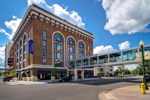 un gran edificio de ladrillo con un puente delante de él en Hilton Garden Inn Kalamazoo Downtown, en Kalamazoo