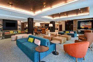 a living room with a blue couch and chairs at Hilton Garden Inn Kalamazoo Downtown in Kalamazoo