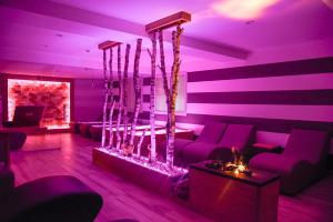 a living room with purple lighting and couches and a table at Bella Hotel & Restaurant with private dock for mooring boats in San Felice del Benaco