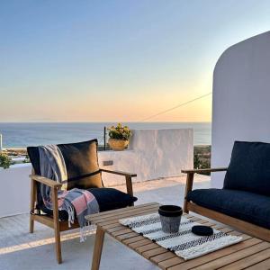 a patio with two chairs and a table and the ocean at Pytilia in Agiassos