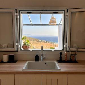 a kitchen with a sink and a large window at Pytilia in Agiassos