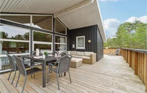 a patio with a table and chairs on a deck at Awesome Home In lbk With 4 Bedrooms, Sauna And Wifi in Skram