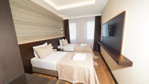 a hotel room with two beds and a flat screen tv at Bellezza Hotel in Istanbul