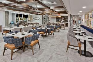 Doubletree By Hilton Dothan, Al في دوثان: مطعم فيه طاولات وكراسي في الغرفة