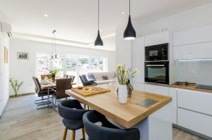 a kitchen and dining room with a wooden table and chairs at Villa Tranquility Nest Beniva in Mokošica