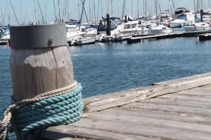 ein Seil, das an ein Dock mit Booten im Wasser gebunden ist in der Unterkunft Ferienwohnungen Haus Anna OFC 26 in Kühlungsborn