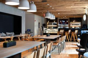 a restaurant with wooden ceilings and tables and chairs at The Lloyd Stamford, Tapestry Collection by Hilton in Stamford