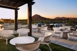 d'une terrasse sur le toit avec des chaises et des tables. dans l'établissement Canopy By Hilton Scottsdale Old Town, à Scottsdale