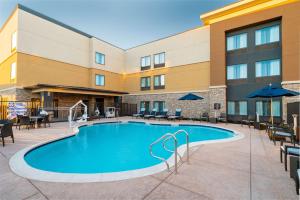 uma piscina em frente a um hotel com mesas e cadeiras em Homewood Suites By Hilton Livermore, Ca em Livermore