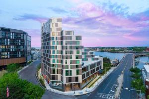 ボストンにあるHomewood Suites by Hilton Boston Seaport Districtの川の横の白い高い建物