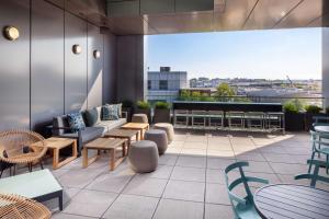 Homewood Suites by Hilton Boston Seaport District في بوسطن: فناء على طاولات وكراسي في مبنى