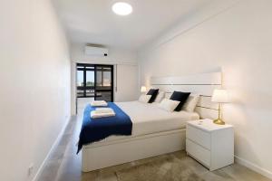 Un dormitorio blanco con una cama grande y una ventana en Heaven's House, en Cascais